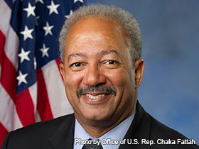 Representative Chaka Fattah wearing a suit poses in front of US flag.