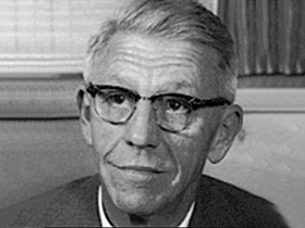 Black and white photograph of Herman Fisher wearing horn rimmed glasses.