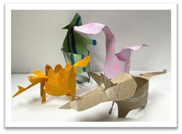 four dinosaurs made from paper rolls cut to look like a stegosaurus, triceratops, brontosaurus, and tyrranosaurus rex